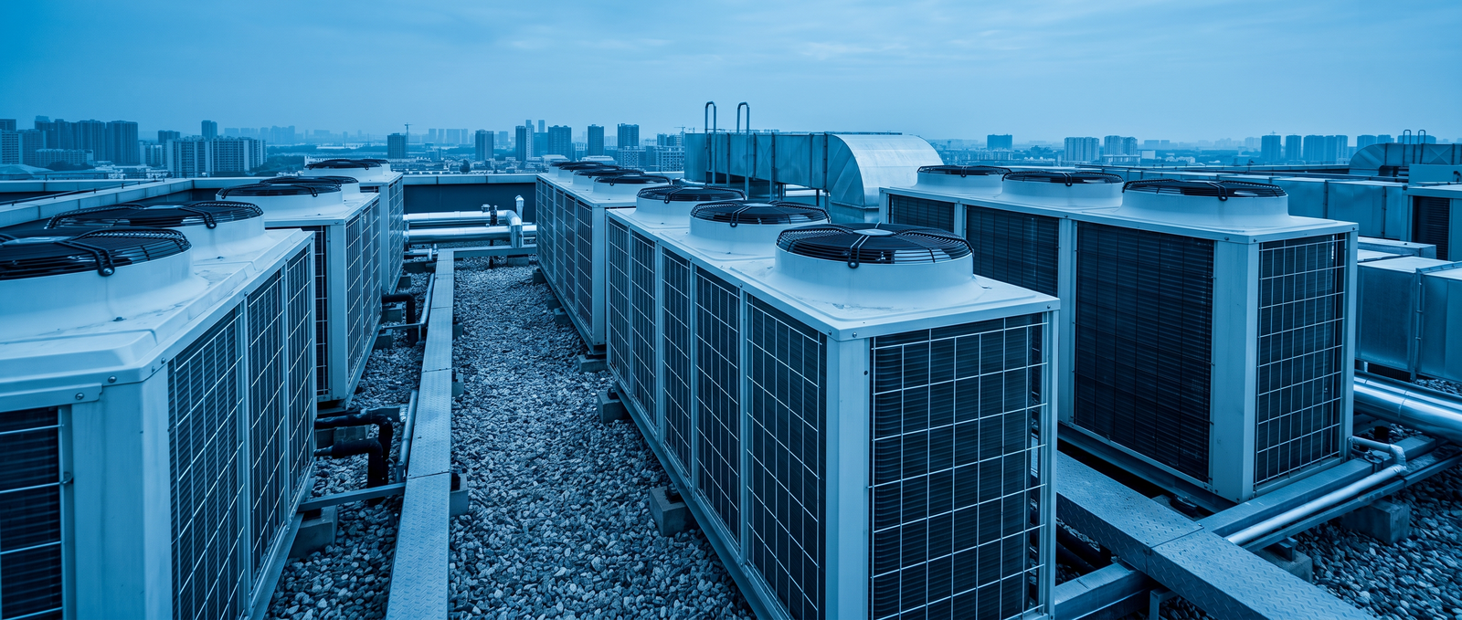 Rooftop HVAC air-conditioning units overlooking a city skyline